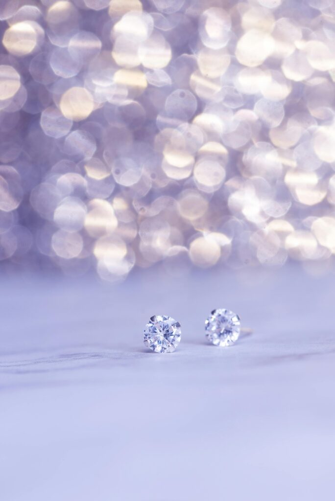 Close-up shot of sparkling diamond earrings against a beautiful bokeh background, showcasing luxury.